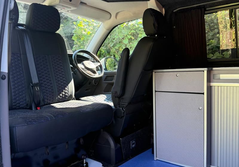 Cuddy interior from side door showing front seats and kitchen unit