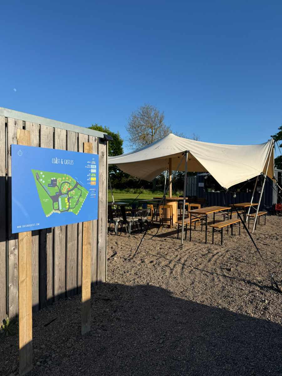 The stretch tent and outdoor seating area at The Gin Tin bar at Coast and Castles in daytime