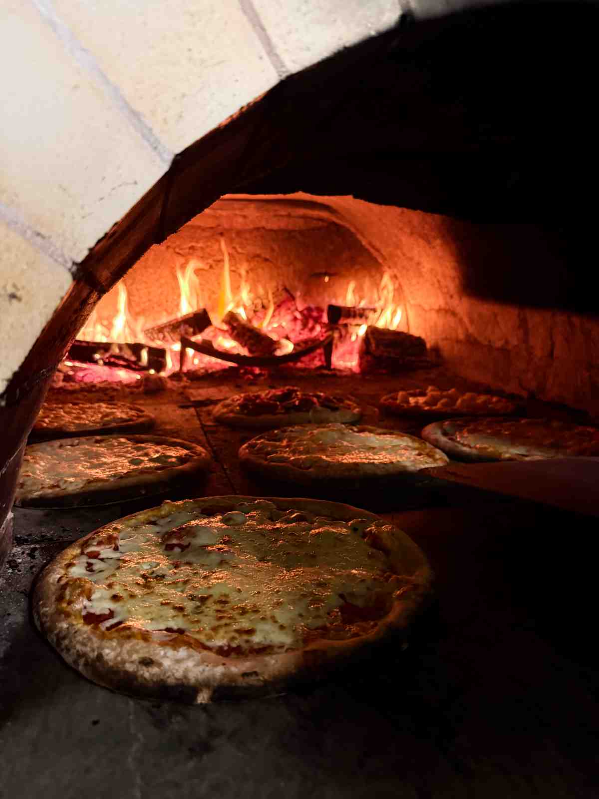 Pizzas cooking in the wood-fired oven at Coast and Castles