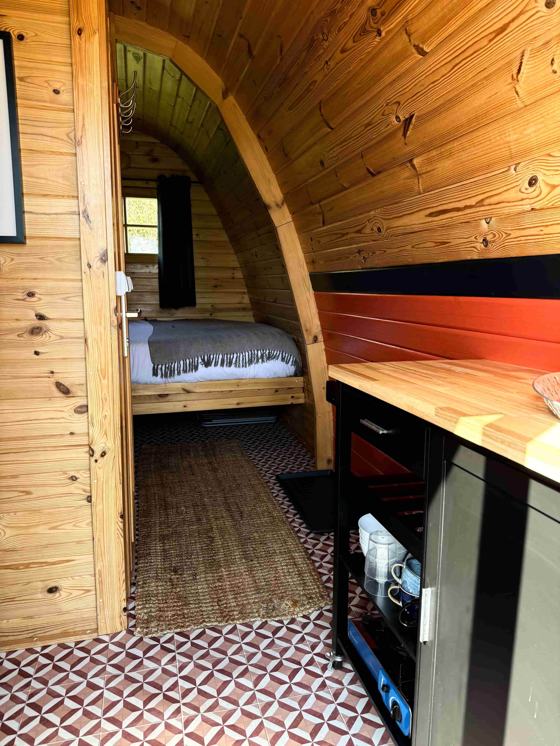 Inside a glamping pod at Coast and Castles — double bed, warm lighting and private toilet